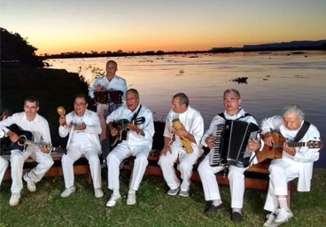 Foto do Grupo Acaba tocando ao fundo com por do sol e rio praguai