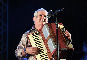 Foto Dino Rocha tocando acordeon em um placo